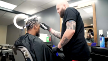 Coco Hernandez cutting Marcus Smart's hair.