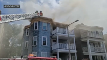 Firefighters battle a blaze in Boston's Dorchester neighborhood on Friday, July 15, 2022.