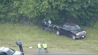 An injured bear being taken out of the median on I-495 on Raynham, Massachusetts, on Thursday, June 23, 2022. The bear later died, officials said.