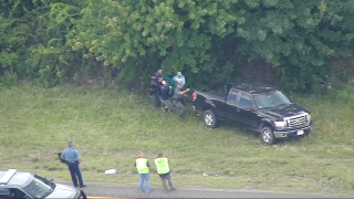 An injured bear being taken out of the median on I-495 on Raynham, Massachusetts, on Thursday, June 23, 2022. The bear later died, officials said.