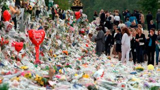 Mourners file past the tributes left in memory of Diana Princess of Wales at Kensington Palace