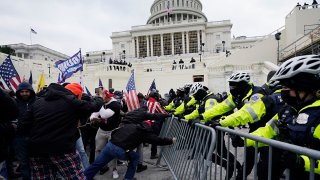 FILE - Insurrectionists loyal to President Donald Trump try to break through a police barrier, Jan. 6, 2021, at the Capitol in Washington.