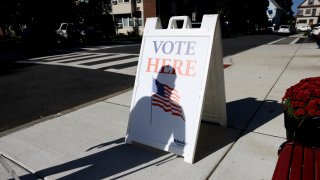 Everett, MA – September 21: A man casts his shadow on a sign outside of a polling place in Everett, MA on September 21, 2021. (Photo by Jessica Rinaldi/The Boston Globe via Getty Images)