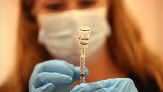 Safeway pharmacist Ashley McGee fills a syringe with the Pfizer COVID-19 booster vaccination at a vaccination booster shot clinic on October 01, 2021 in San Rafael, California.