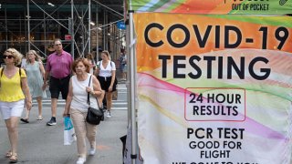 People walk past a COVID-19 walk up testing site on July 28, 2022 in New York City.