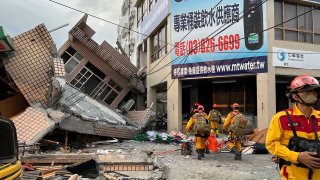 This photo provided by Hualien County fire department show firefighters in the search for trapped victims in a collapsed residential building
