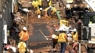 Orange Line work being done on the tracks in the Southwest Corridor in Jamaica Plain not far from the Jackson Square T Station on Tuesday, Aug. 30, 2022, as workers use tools to take out the old wooden railroad ties.