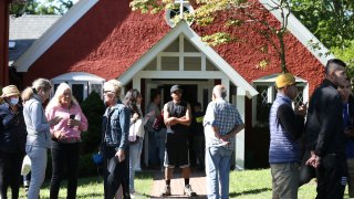 Volunteers mingle outside of St. Andrews Episcopal Church. Two planes of migrants from Venezuela arrived suddenly Wednesday night on Martha's Vineyard. The migrants are being taken care of at the church for now.