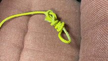 a photo of a noose tied in neon rope on an office chair
