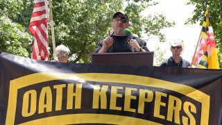 FILE - Stewart Rhodes, founder of the Oath Keepers, center, speaks during a rally outside the White House in Washington, June 25, 2017.