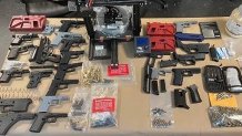 Guns and gun fragments on table as evidence in police investigation