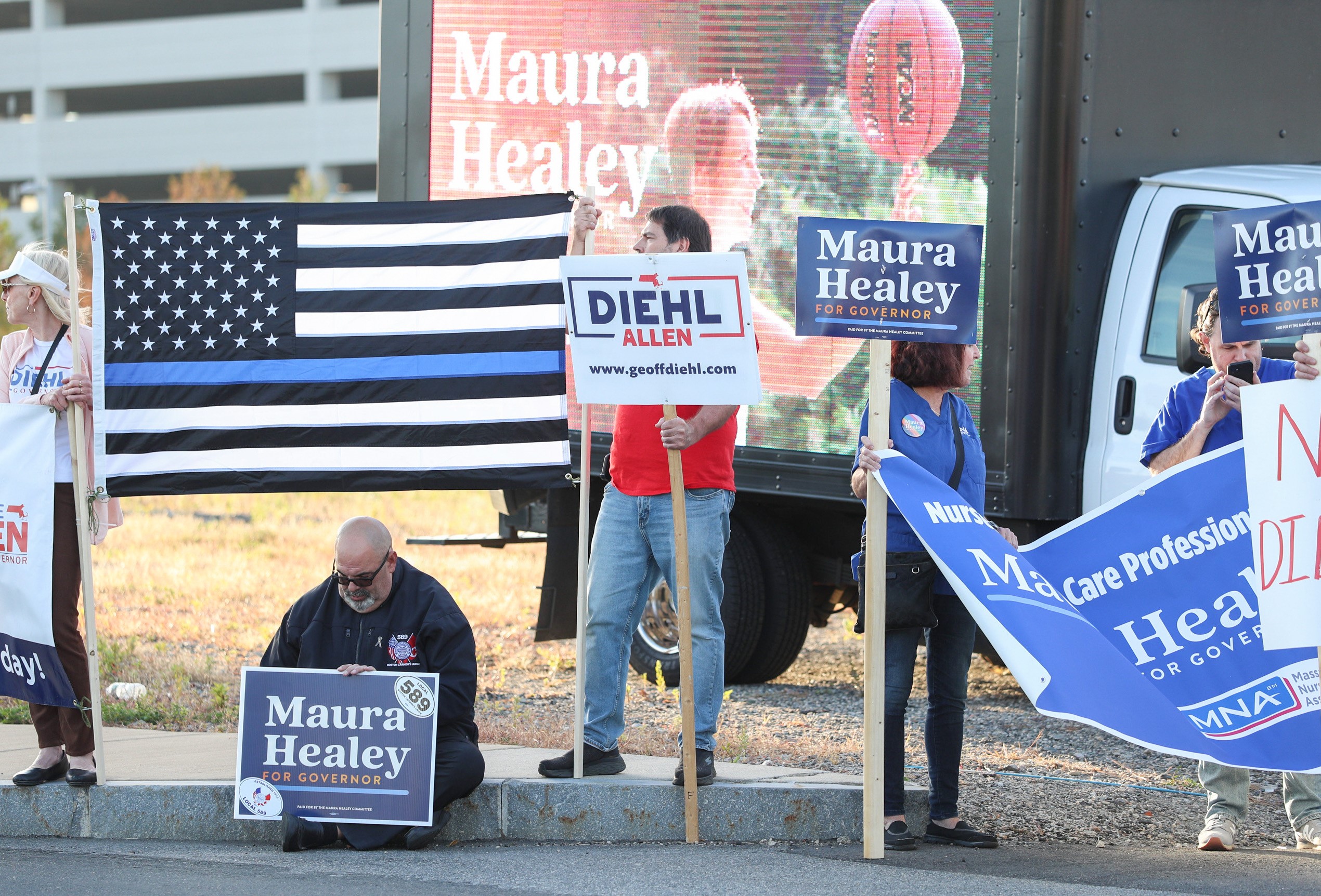 Supporters of Democrat Maura Healey and Republican Geoff Diehl outside the Boston Media Center before the candidates’ first debate in the Massachusetts governor’s race.