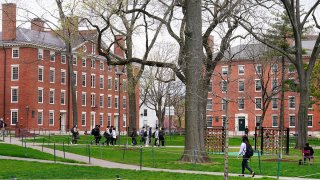 FILE - Students walk through Harvard Yard, April 27, 2022, on the campus of Harvard University in Cambridge, Mass.