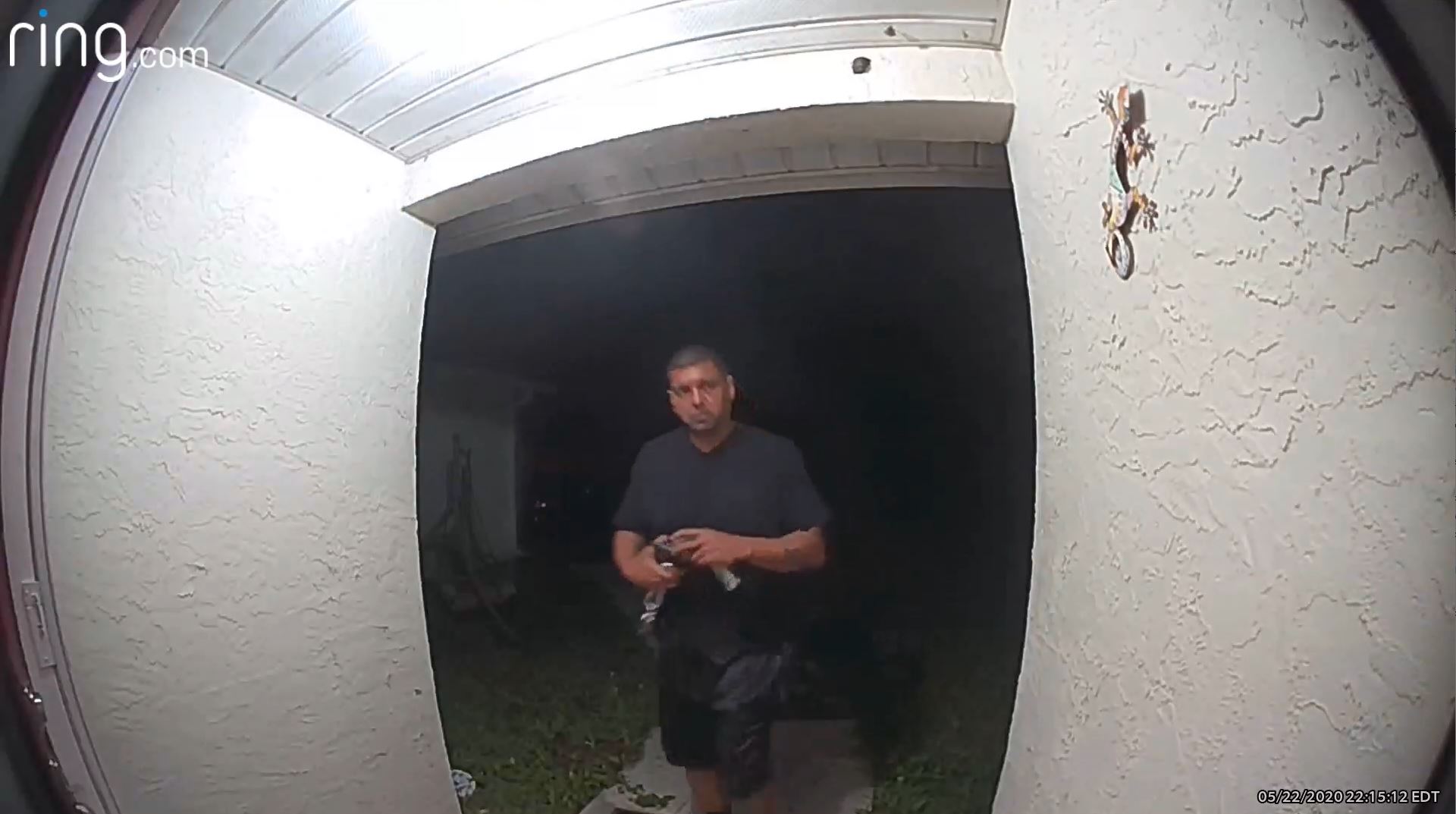 a ring doorbell surveillance image shows a man approaching a door