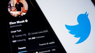 In this photo illustration a Twitter logo seen displayed on a smartphone screen with Elon Musk Twitter in the background in Athens, Greece on October 30, 2022. Elon Musk begins his Twitter ownership with firings.