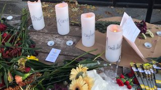 Candles and flowers are left at a memorial honoring four slain University of Idaho students outside the Mad Greek restaurant in downtown Moscow, Idaho, on Nov. 15, 2022.