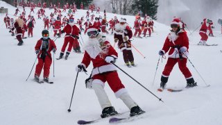 Skiers dressed in Santa Claus outfits hit the slopes for charity at the Sunday River Ski Resort, Sunday, Dec. 11, 2022, in Newry, Maine.