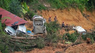 Rescue teams continue the search for victims caught in a landslide