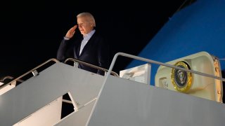 President Joe Biden salutes as he boards Air Force One at Andrews Air Force Base, Md., on Dec. 27, 2022.