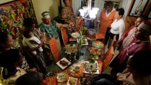 Friends and family join hands to share Kwanzaa blessings before eating special dishes prepared by Maisie McNaught at her home in Miami Gardens, Florida, December 6, 2007.  (Photo by John VanBeekum/Miami Herald/Tribune News Service via Getty Images)