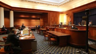 Boston, MA – March 9: Attorney John Kappos, standing rear left, argues for the doctor in Boston on March 9, 2022. The Supreme Judicial Court hears oral arguments in Roger M. Kligler & Dr. Alan Steinbach vs. Maura Healey & Michael OKeefe. Dr. Roger Kligler, who has incurable metastatic prostate cancer, wants doctors to be able to prescribe lethal amounts of drugs to terminally ill patients with six months or less to live, without fear of prosecution. The states highest court on Wednesday weighed arguments in a Cape Cod doctors controversial right-to-die case, with justices questioning whether the times, law, and medicine had evolved to make it time to legalize medically assisted death and whether the decision should be left to the Legislature. (Photo by Pat Greenhouse/The Boston Globe via Getty Images)