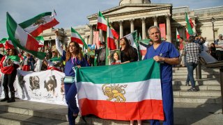 FILE - Iranians protesters hold flags of Iran