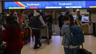Passengers line up by the Southwest Airlines counter at San Francisco International Airport (SFO) in San Francisco, California, on Dec. 26, 2022.