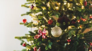 Close up of balls. Christmas tree with bright golden and red balls, sparkling garland on christmas tree.