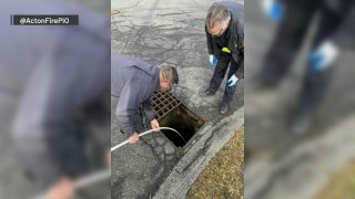 Firefighters saving a doll from a storm drain in Acton, Massachusetts, on Thursday, Jan. 19, 2023.