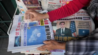 Business owner "Annie" weights down copies of the Chinese Daily News newspaper showcasing pictures of a suspected Chinese spy balloon, in the Chinatown