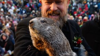 Groundhog handler AJ Derume holds Punxsutawney Phil, who saw his shadow, predicting a late spring during the 136th annual Groundhog Day festivities, Feb. 2, 2022, in Punxsutawney, Pennsylvania.