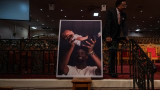 A poster of Tyre Nichols holding his daughter