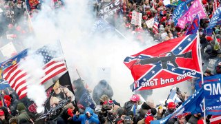 Tear gas is released into a crowd of protesters, with one wielding a Confederate battle flag that reads “Come and Take It,” during clashes with Capitol police at a rally to contest the certification of the 2020 U.S. presidential election results by the U.S. Congress, at the U.S. Capitol Building in Washington, U.S, January 6, 2021.