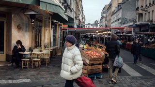 Shoppers pass fruit and vegetable stalls in the Bauveau Market in Paris, France, on Wednesday, Feb. 15, 2023.