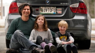 Peter Starostecki and his kids Sadie, center, and Jo Jo, pose behind their car