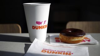 A black coffee and chocolate frosted donut are arranged for a photograph inside a Dunkin' location in Mount Washington, Kentucky, on Jan. 30, 2020.