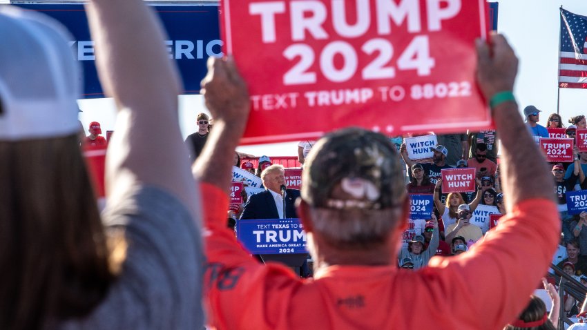 Supporters hold signs as former US President Donald Trump speaks at a campaign event in Waco, Texas, US, on Saturday, March 25, 2023. A defiant Trump railed against the investigations he faces and predicted hed prevail during a rally in Waco that may be the former presidents last public appearance before he faces potential criminal charges.