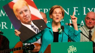 BOSTON, MA – MARCH 18: U.S. Senator Elizabeth Warren holds up a picture of Joe Biden with Donald Trump’s hair during the annual St. Patrick’s Day Breakfast at the Ironworkers Local 7 Union Hall in South Boston on March 18, 2018. (Photo by Jessica Rinaldi/The Boston Globe via Getty Images)
