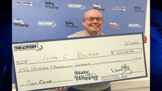 John Butler with a ceremonial check commemorating his Massachusetts Lottery win.