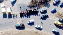 A rolled-over dump truck spilled gravel on the Bourne Rotary in Bourne, Massachusetts, on Tuesday, March 21, 2023.