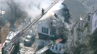 Firefighters battling a blaze at a home in Holbrook, Massachusetts, on Tuesday, March 21, 2023.