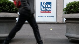 People walk by the News Corporation headquarters, home to Fox News, on April 18, 2023 in New York City.