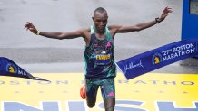 Evans Chebet, of Kenya, breaks the tape at the finish line, winning the men's division of the Boston Marathon, April 17, 2023.