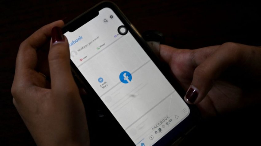 A woman uses her mobile phone to check Facebook in Yangon on February 4,2021 as Myanmar’s generals ordered internet providers to restrict access to Facebook, days after they seized power.