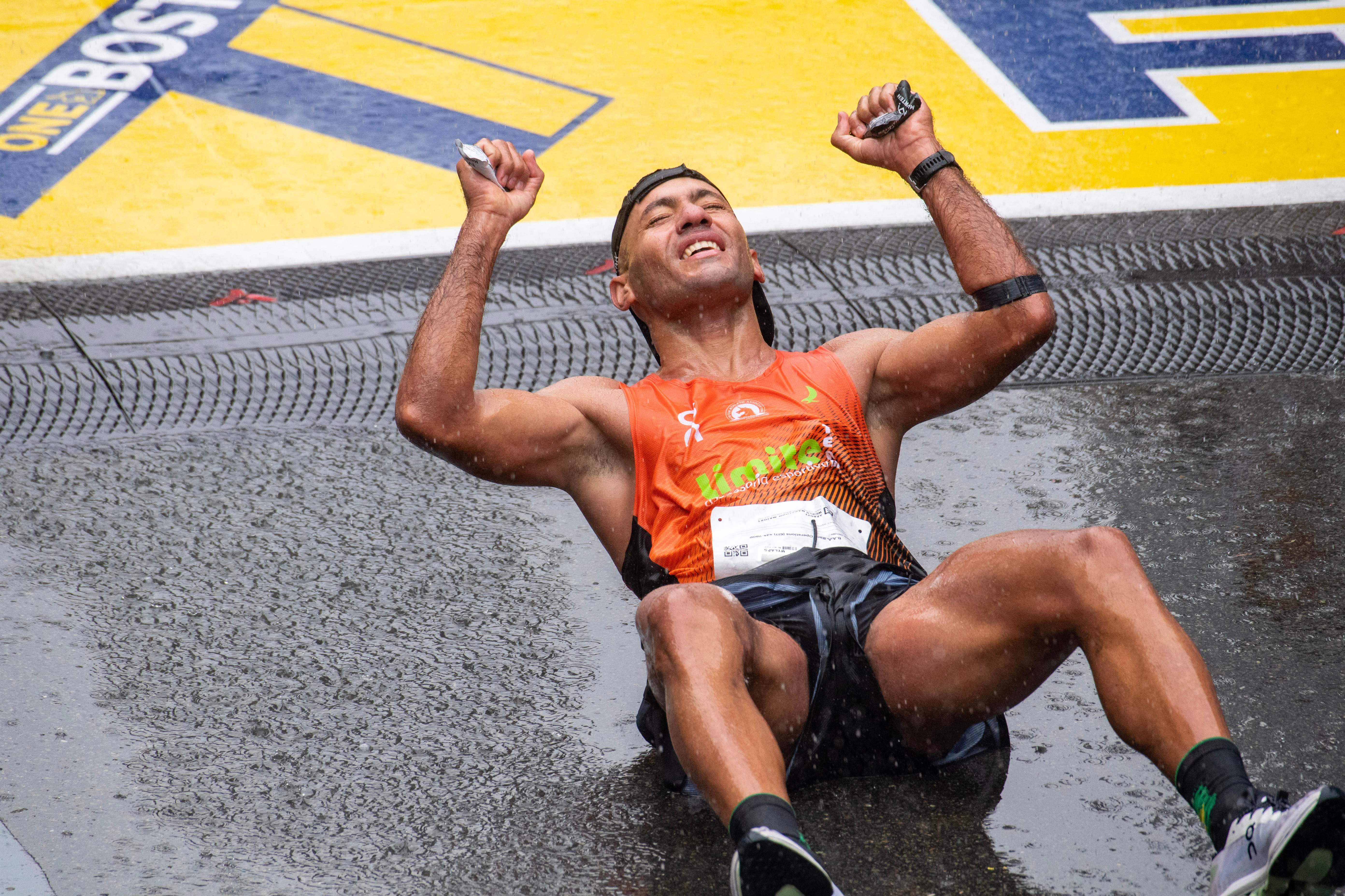 A runner celebrates at the finish line during the 127th Boston Marathon in Boston, Massachusetts, on April 17, 2023. – In wet and windy conditions, 2022 champion Chebet of Kenya took his time before surging away in the closing stages to become the first man to defend the Boston crown since compatriot Robert Kipkoech Cheruiyot completed a hat trick of victories between 2006-2008. (Photo by Joseph Prezioso / AFP) (Photo by JOSEPH PREZIOSO/AFP via Getty Images)