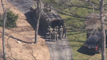 A person being taken into custody at a home in Dighton, Massachusetts, on Thursday, April 13, 2023.