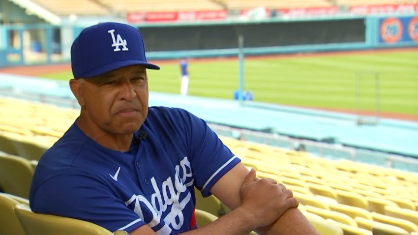 Los Angeles Dodgers manager Dave Roberts sits on a chair at an empty Dodger Stadium.