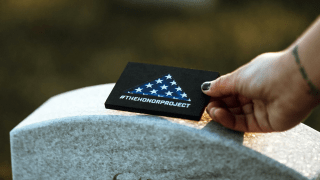 A volunteer with The Honor Project visits a service member's grave on a previous Memorial Day.