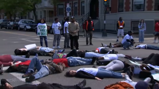 A group protesting gun violence in Boston blocks an intersection in Dorchester on Wednesday, May 17, 2023.