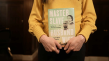 Ilyon Woo holding her book, "Master Slave Husband Wife"